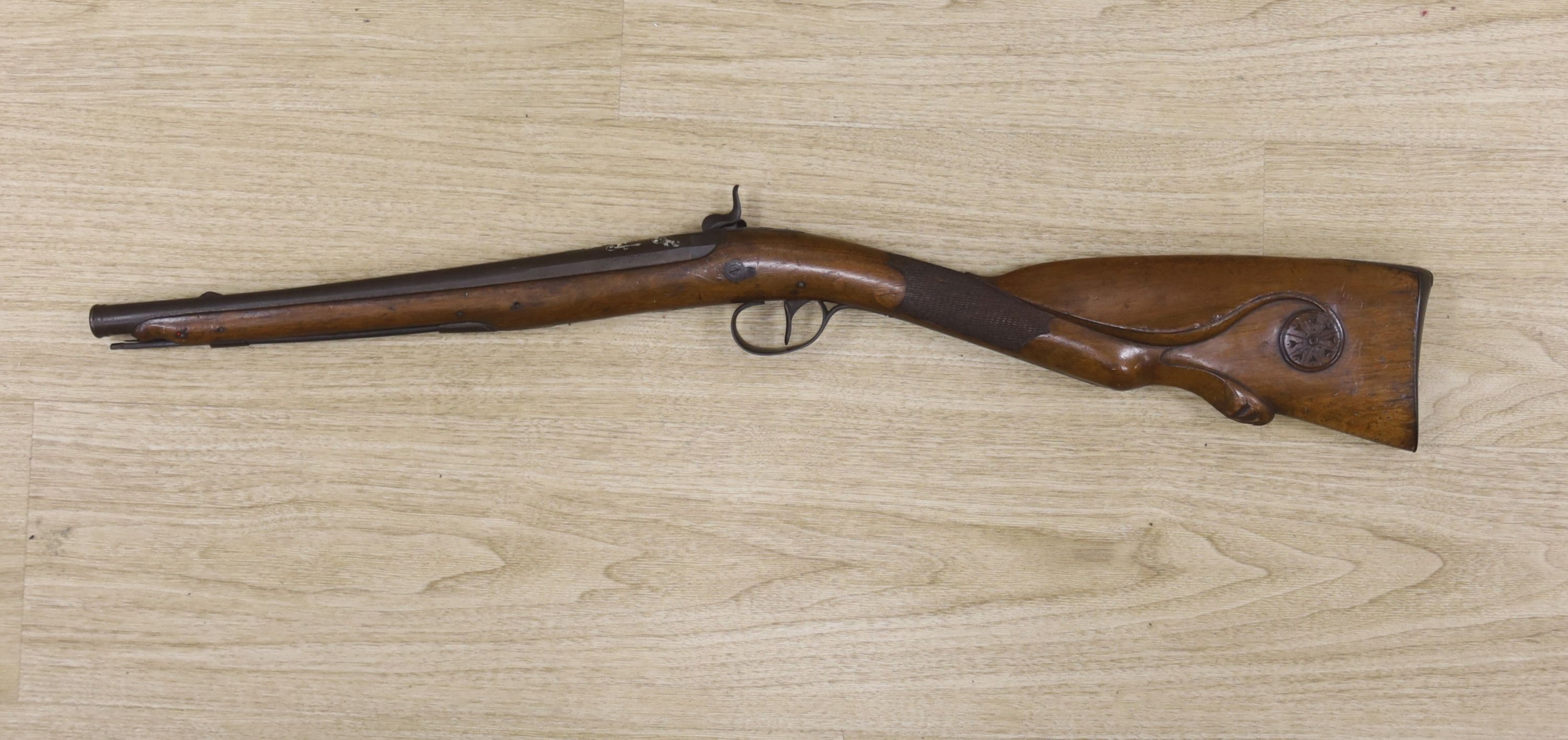 An early 19th century Belgian percussion cap carbine with carved walnut stock and silver inlaid barrel, bears indistinct mark, barrel 38cm, overall length 78cm